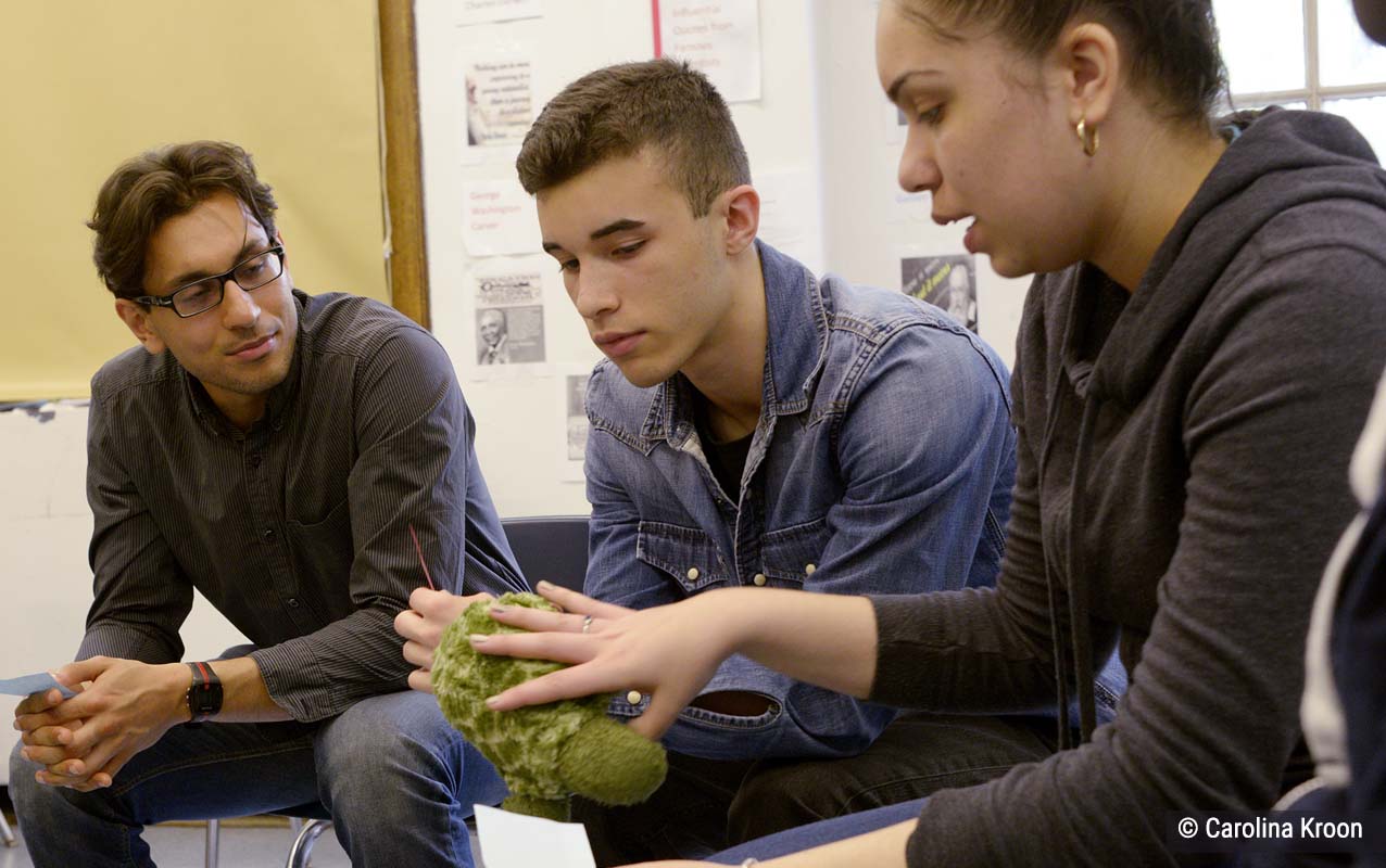 Students and a teacher participate in a circle