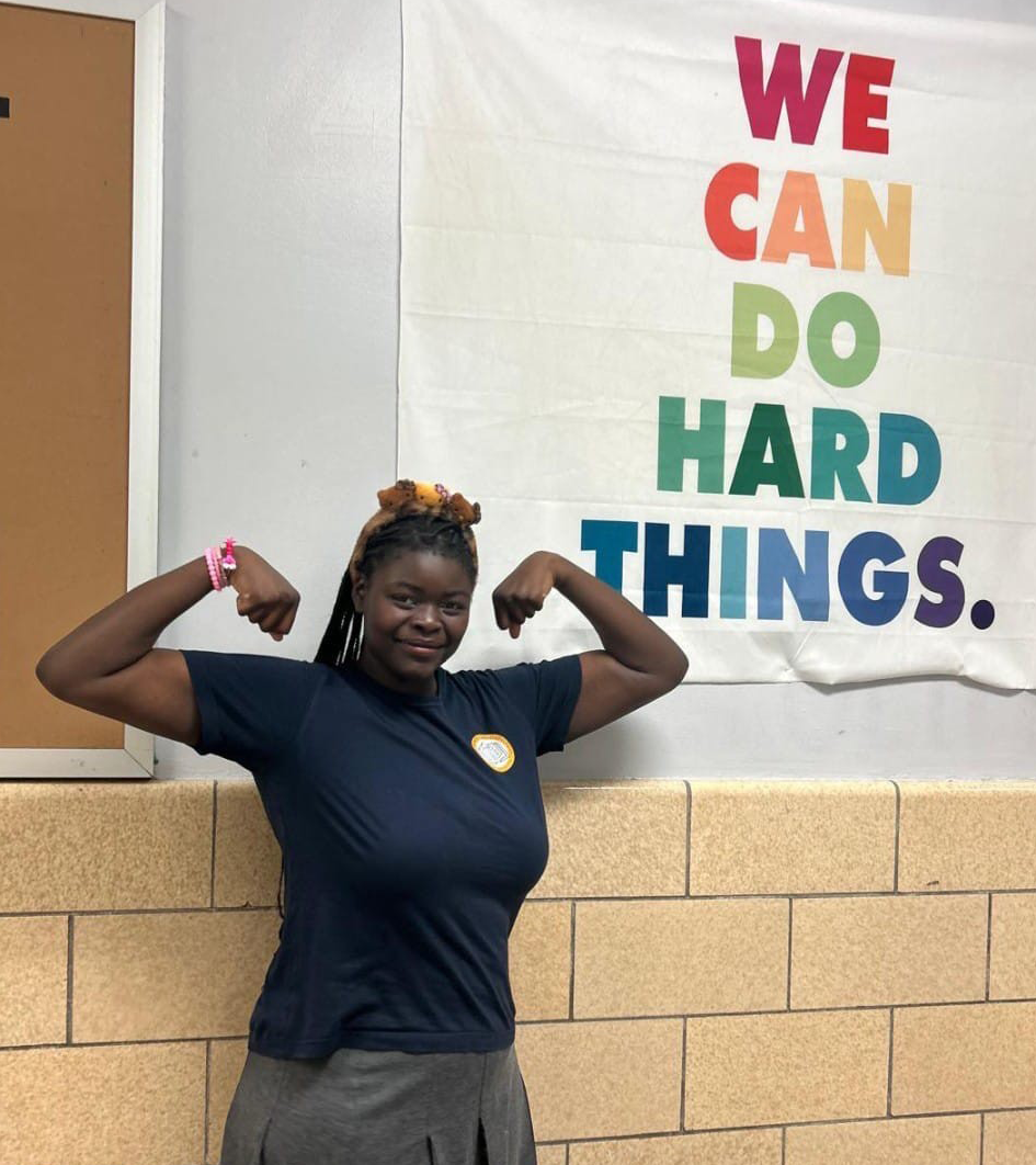 A student standing in front of a bulletin board
